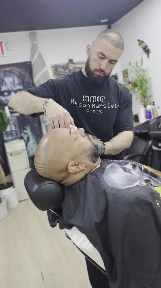 Barber shaving a reclined client